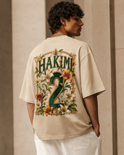 Model wearing the MIRAZUR Atlas Energy 2 Morocco-inspired oversized football T-shirt in Sand with floral number 2 back print